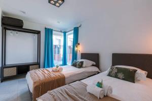 twee bedden in een kamer met blauwe gordijnen bij Family-Friendly House with sunny terrace and garden in Oostende
