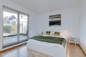 um quarto branco com uma cama e uma grande janela em Stylish apartment with terrace and balcony em Antuérpia
