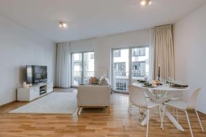 uma sala de estar com uma mesa branca e cadeiras em Stylish apartment with terrace and balcony em Antuérpia