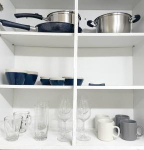 une étagère blanche avec des verres, des bols et des tasses dans l'établissement #guro digital complex station 10min #clean #2rooms #netflix, à Séoul