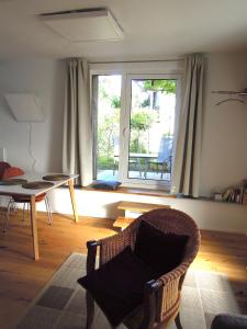 Nollingen的住宿－Stilvolle Ferienwohnung in Rheinfelden，客厅配有椅子和桌子