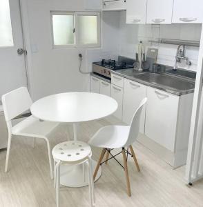 uma cozinha branca com uma mesa e cadeiras brancas em #guro digital complex station 10min #clean #2rooms #netflix em Seul