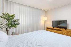 une chambre avec un lit et une télévision à écran plat dans l'établissement #guro digital complex station 10min #clean #2rooms #netflix, à Séoul