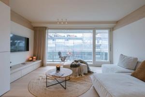 ein Wohnzimmer mit einem Sofa und einem Tisch in der Unterkunft Luxurious two bedroom near the sea in Knokke-Heist