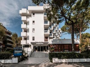里乔内Augustus Hotel Riccione的一栋白色建筑，前面有树