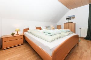 a large bed with white sheets and pillows on it at Ferienwohnung Morgenrot im Haus Auszeit Crusoh in Schweindorf