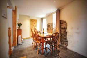 a dining room with a wooden table and chairs at Y Boidy Bach Llangrannog in Llangranog