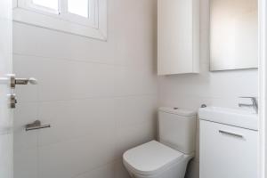 biała łazienka z toaletą i umywalką w obiekcie AB Nou de la Rambla w Barcelonie