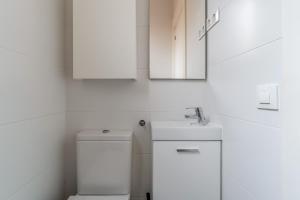 een badkamer met een toilet, een wastafel en een spiegel bij AB Nou de la Rambla in Barcelona