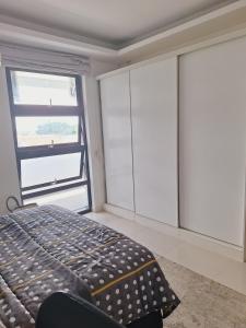a bedroom with a bed and a large window at Sophisticated apartment in Maputo