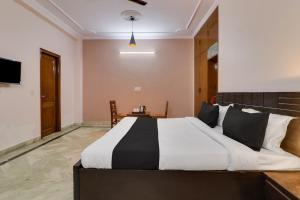 1 dormitorio con 1 cama grande y 1 mesa en Super OYO Dream Homes en Nueva Delhi