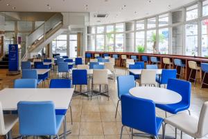 a cafeteria with tables and blue chairs at Toyoko Inn Okinawa Naha Asahibashi Ekimae in Naha