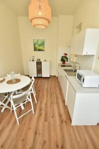 een keuken met witte kasten, een tafel en een magnetron bij Apartment Joja in Ljubljana