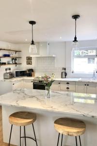 a kitchen with a large marble counter with two stools at Sole Bay Croyde in Croyde