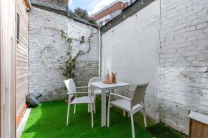 uma mesa e cadeiras num pátio com relva verde em Spacious apartment with terrace in Ostend em Oostende