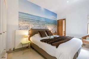 - une chambre avec un lit orné d'une peinture sur l'océan dans l'établissement Spacious apartment with terrace in Ostend, à Ostende
