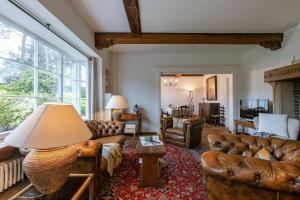 een woonkamer met lederen meubels en een groot raam bij Charming house Heemdael in Knokke-Le-Zoute in Knokke-Heist