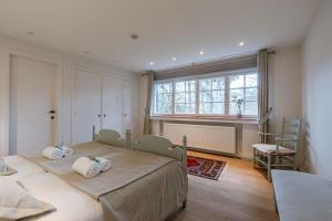 een slaapkamer met 2 bedden en een raam bij Charming house Heemdael in Knokke-Le-Zoute in Knokke-Heist