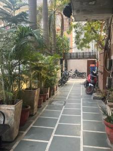 a courtyard with palm trees and motorcycles in a building at Hotel Saket Place - Near Saket Metro in New Delhi
