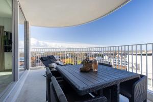 Una mesa y sillas en un balcón con vista. en Huswell - Bright apartment with seaview, en Bredene
