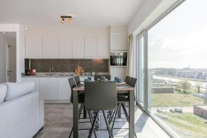 eine Küche und ein Esszimmer mit einem Tisch und Stühlen in der Unterkunft Bright apartment with seaview in Bredene