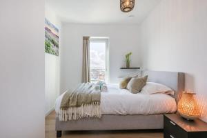 um quarto com uma cama grande e uma janela em Bright apartment with seaview em Bredene