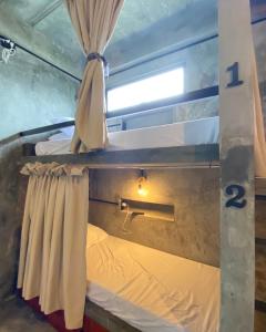 San IsidroにあるKatre Siargao - SELF CHECK-IN Hostelの二段ベッド2台と窓が備わる客室です。