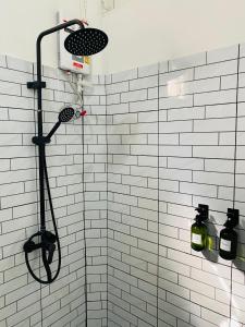 a shower in a bathroom with white tiles at The 10 club hostel in Thong Sala