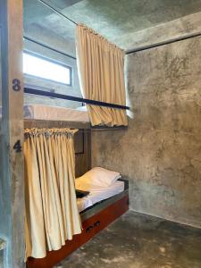 Etagenbett in einem Zimmer mit Fenster in der Unterkunft Katre Siargao - SELF CHECK-IN Hostel in San Isidro