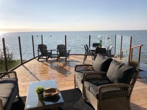 una terraza con sillas, un sofá y una mesa en Exclusieve vakantievilla ***** Markermeer, en Bovenkarspel