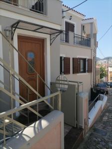a building with a wooden door and a staircase at PERGAMOS APARTMENTS in Mytilene