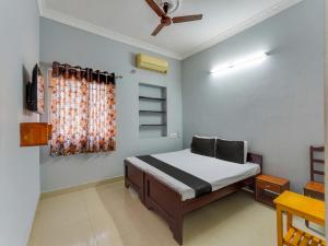 a bedroom with a bed and a ceiling fan at OYO Blue jay in Chennai