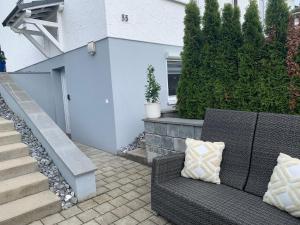 a patio with a wicker couch and stairs at Am Sonnenhang in Hilzingen