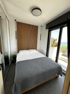 a bedroom with a bed and a large window at Sunrise and Sunset Palio Sea View Appartment in Kavala +31 photos
