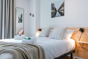 a bedroom with a white bed with a blanket on it at Cosy apartment with frontal seaview in Nieuwpoort