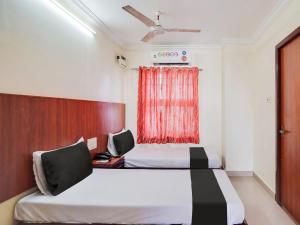 Habitación de hotel con 2 camas y ventana en OYO Meenaachi Inn, en Chennai