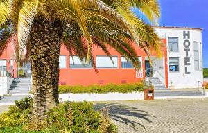 a palm tree in front of a building at Casa Do Vale Hotel in Évora