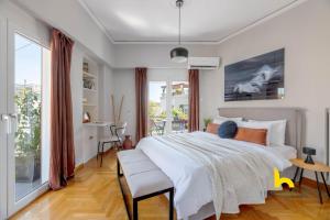 a bedroom with a large white bed and a desk at Sun-splashed sanctum with big balconies, Acropolis in Athens