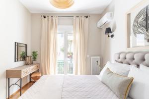 a white bedroom with a bed and a desk at Discover Athens from Urban Hideaway, Acropolis View in Athens