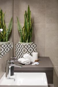 a bathroom with a sink and two potted plants at Discover Athens from Urban Hideaway, Acropolis View in Athens
