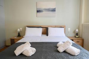 a bedroom with a bed with two towels on it at Stella’s Minimal Lodge in Tríkala