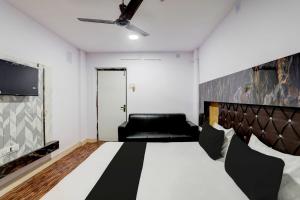 a room with a bed and a black couch at OYO Payal Guest House in Brahmapur