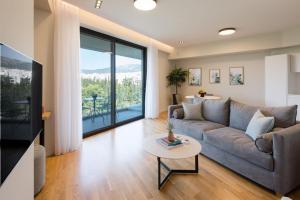 a living room with a couch and a table at Urban APT with Stunning Acropolis View & Roofdeck in Athens