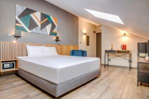 a bedroom with a large white bed and a television at Hotel Forty One in Bucharest