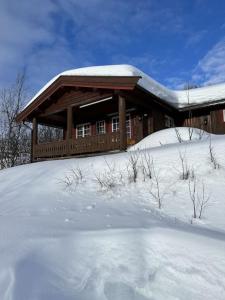 貝圖斯托的住宿－Nostalgi i Stakkstøli，小木屋前面的地面上有雪