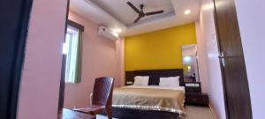 a bedroom with a bed and a ceiling fan at Hotel Jagdish Palace Puri in Puri