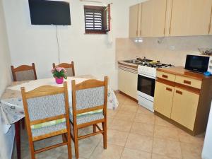 una cocina con una mesa y una estufa horno superior en Apartmani Katica-u blizini plaže "Pisak", en Seline
