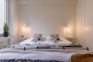 - 2 lits dans une chambre aux murs blancs dans l'établissement Warm & cozy lateral seaview apartment, à Ostende