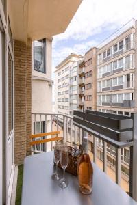 - une table avec des verres à vin et un piano sur le balcon dans l'établissement Warm & cozy lateral seaview apartment, à Ostende