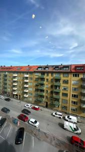 un aparcamiento con coches estacionados frente a los edificios en Luxurious And Spacious Apartment, en Gotemburgo